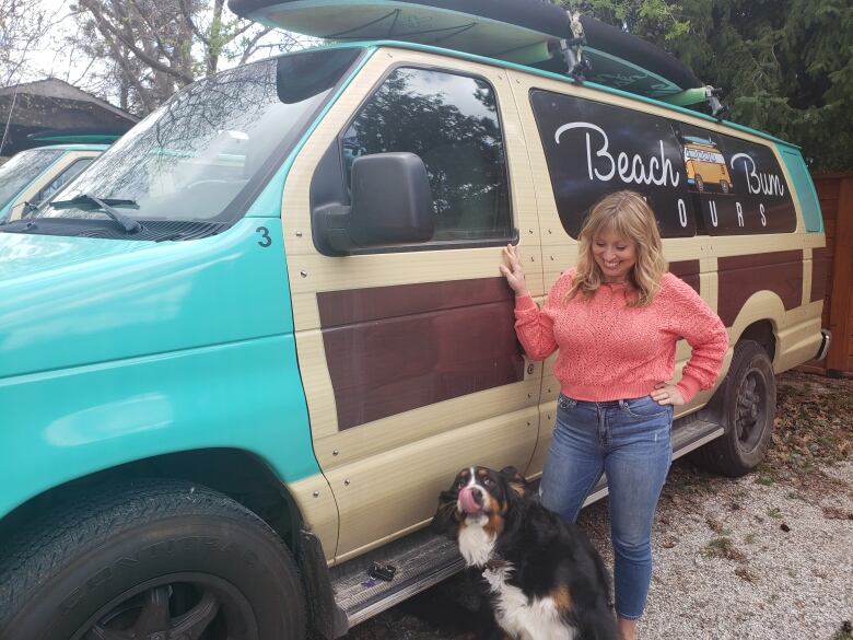 A woman beside a van with a dog.