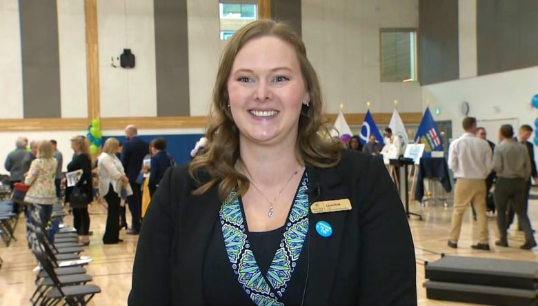 A portrait of a woman standing in a school gymnasium. 