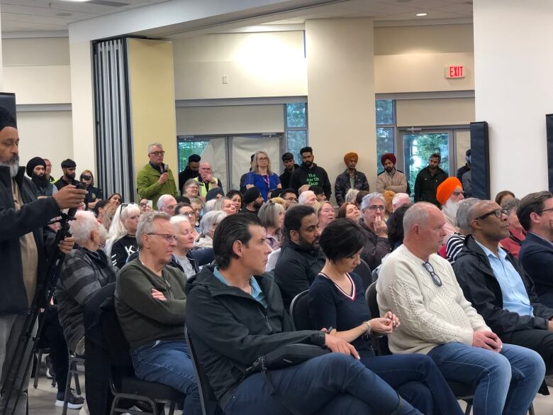 Rows of people in a community centre.