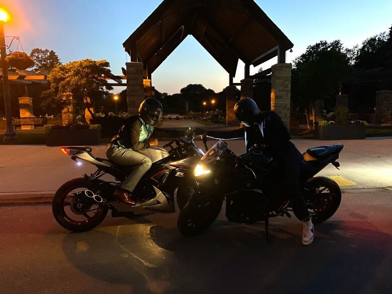 Two helmeted motorcycle riders.