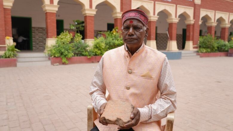 Man holds brick.