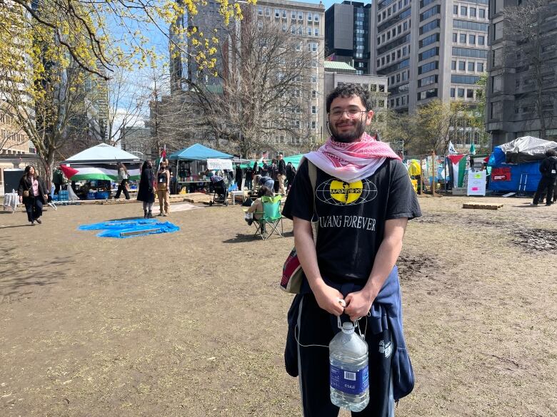 a man smiles at camera holding a big water bottle