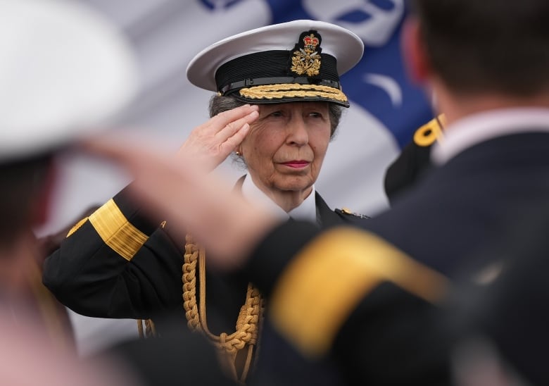 A woman in a naval uniform salutes.