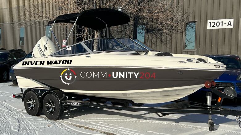 A boat sits in a parking lot.