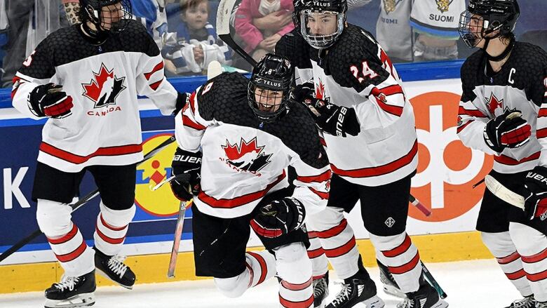 A Canadian U18 men's hockey player dressed in white, red and black jersey celebrates his tying goal against the United States on the power play in Espoo, Finland on May 5, 2024.