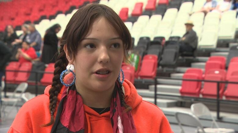 A woman in an orange sweater.