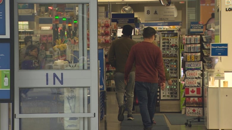 Customers walking inside an automatic door.