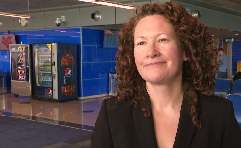 Woman in black blazer and brown curly hair