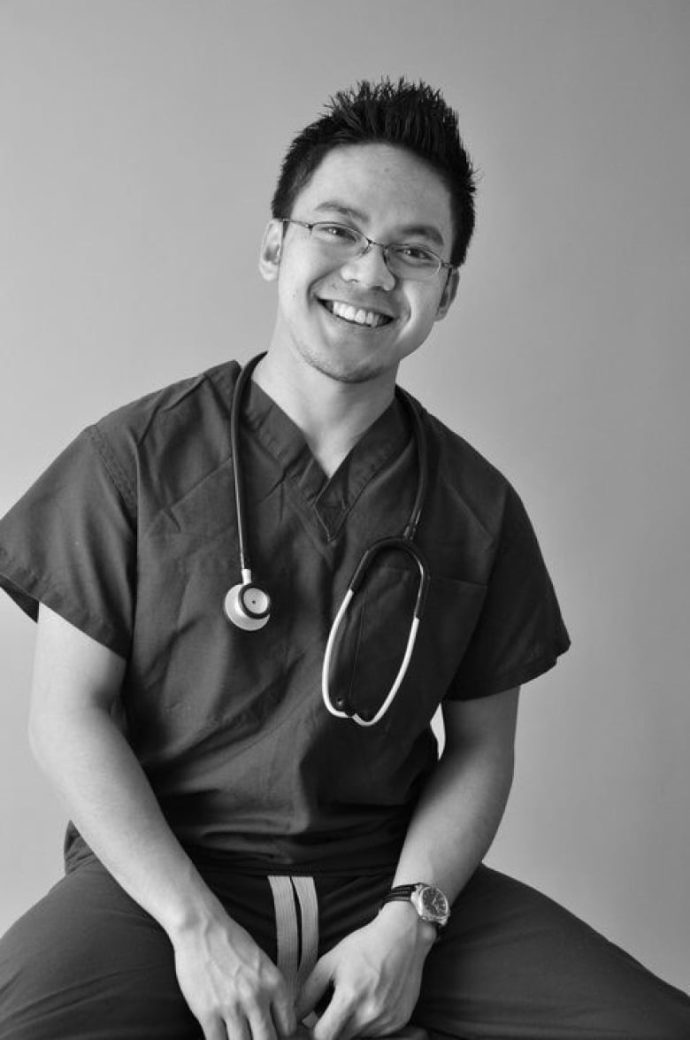 A man wearing scrubs with a stethoscope around his neck.