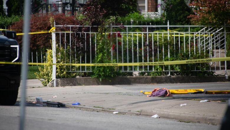 A crime scene on a street with police tape.