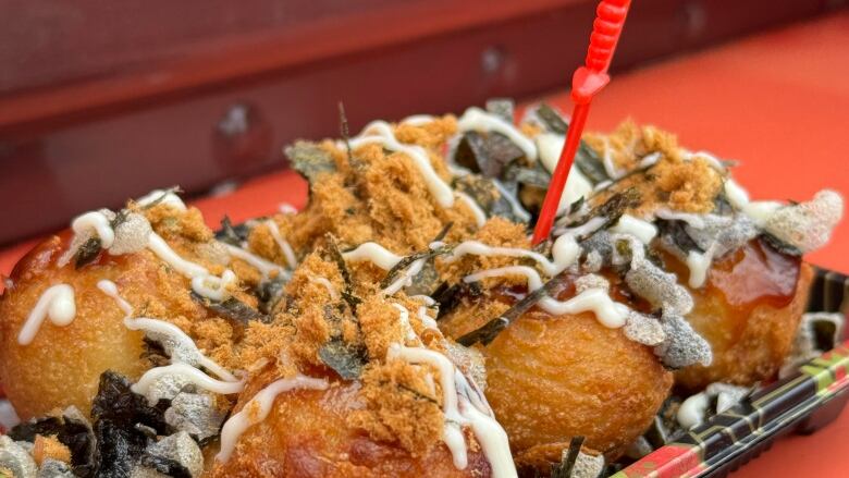 a box of food with ball shaped pieces of fried batter