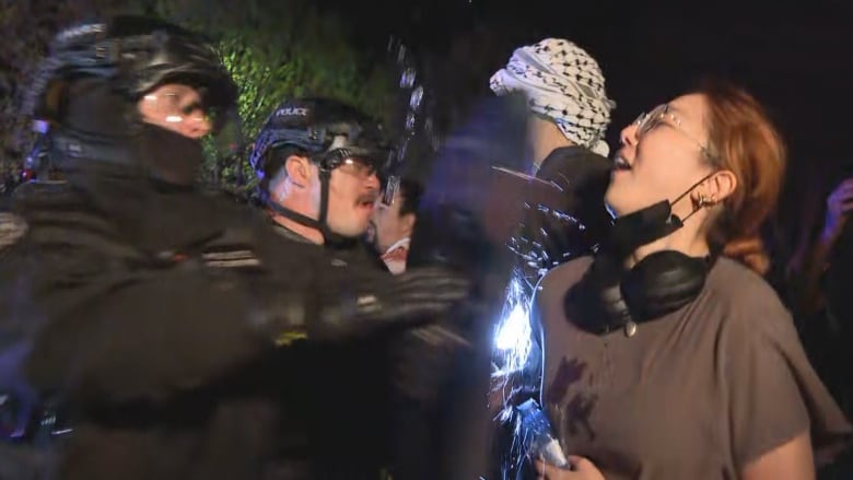 Police with shields clash with protesters.