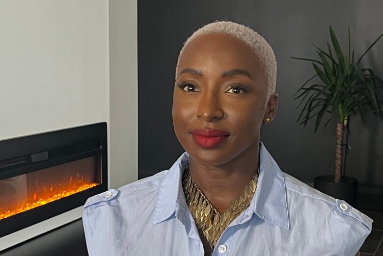 Woman sitting in condo with fireplace in the background.