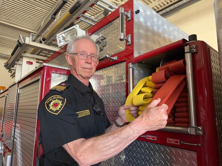 Fire chief Darrell Locke is shown standing by a fire truck at the Shelburne fire hall.