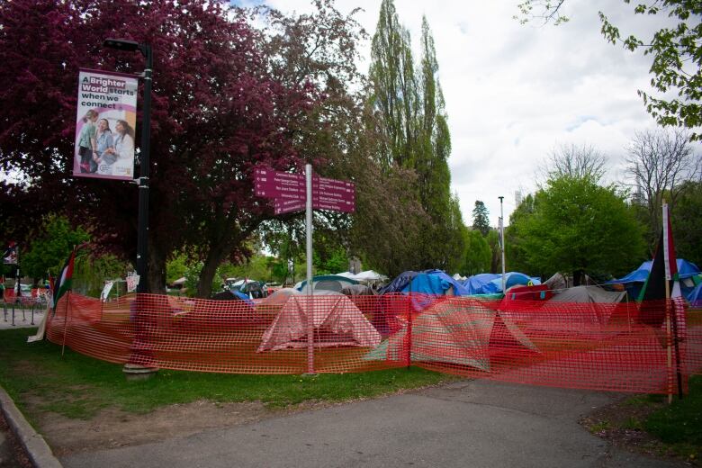 Tents behind a mesh fence.