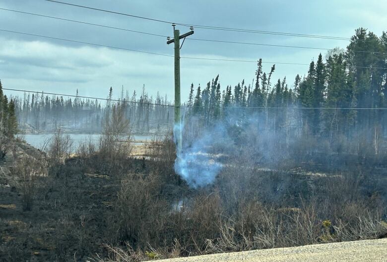 Smoke billows from a burning hydro pole.