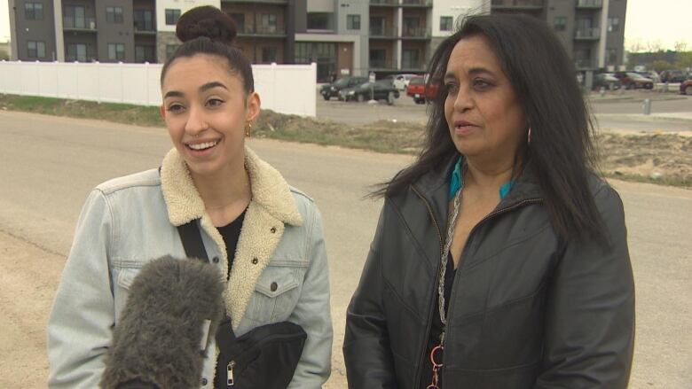 A daughter and her mother are pictured speaking into a microphone.