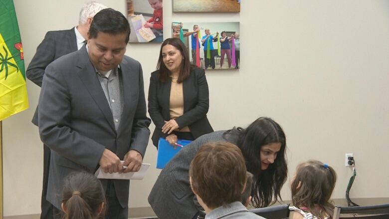 man in a suit talking to children