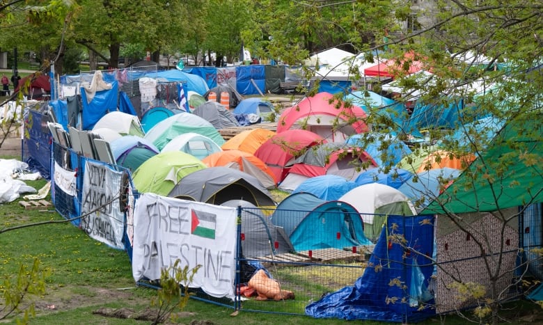 Dozens of tents surrounded by fencing. 