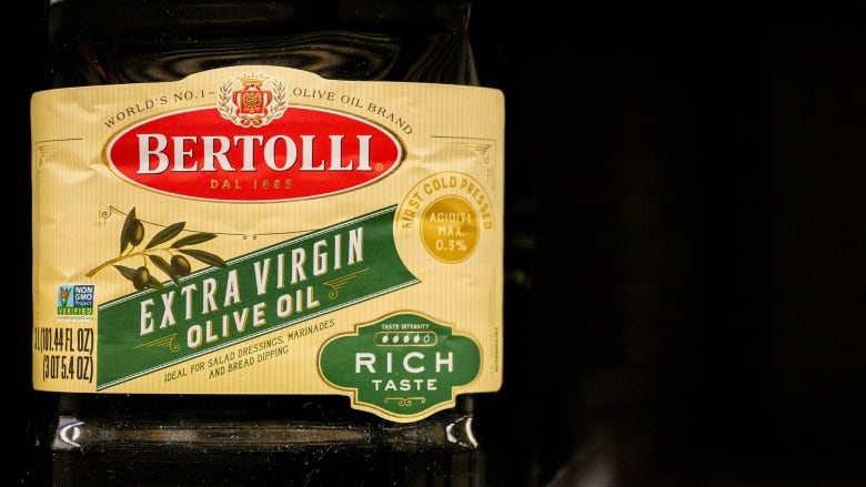 A bottle of Bertolli olive oil sits on a shelf