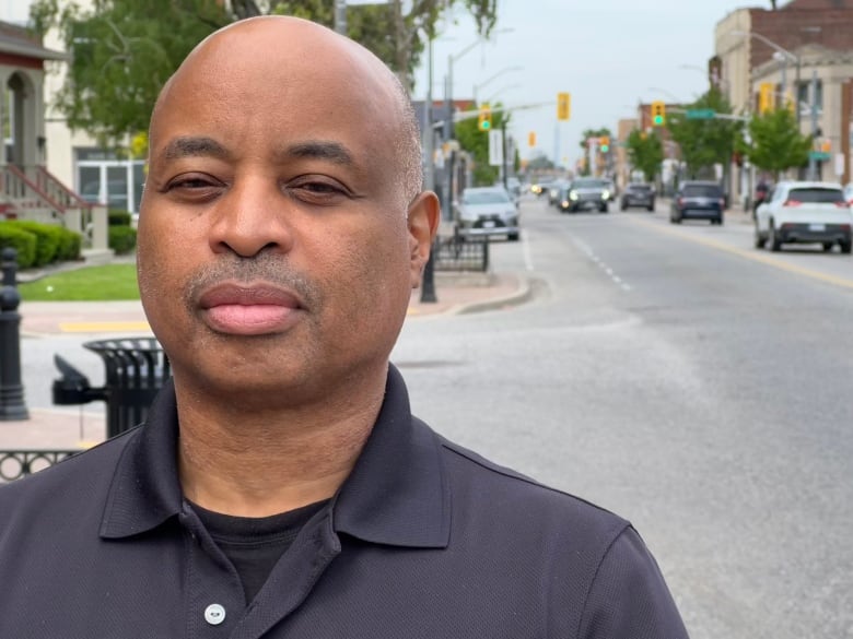 A man stands in front of a streetscape