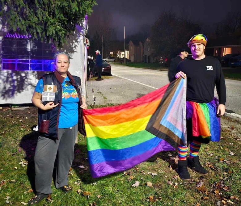 A couple carry a rainbow flag.