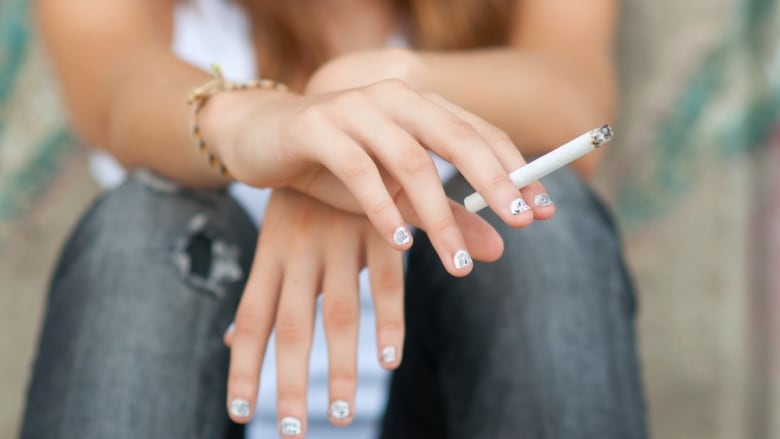 Woman holding cigarette.