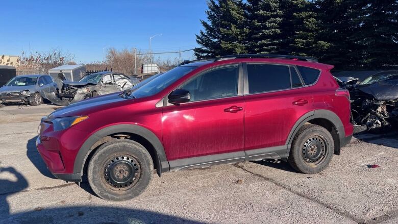 A side view of a red SUV in a parking lot.