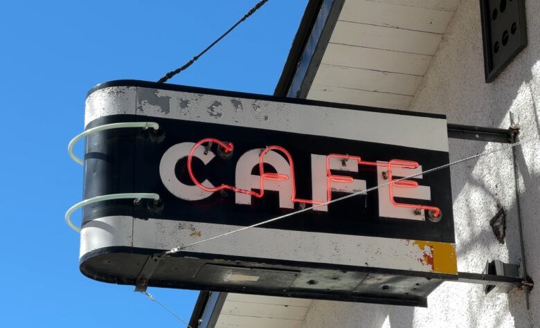 A neon sign spells out the word 'cafe' in red.