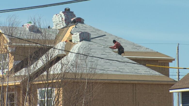 A contractor is shown working on the roof of a home in Upper Tantallon. 