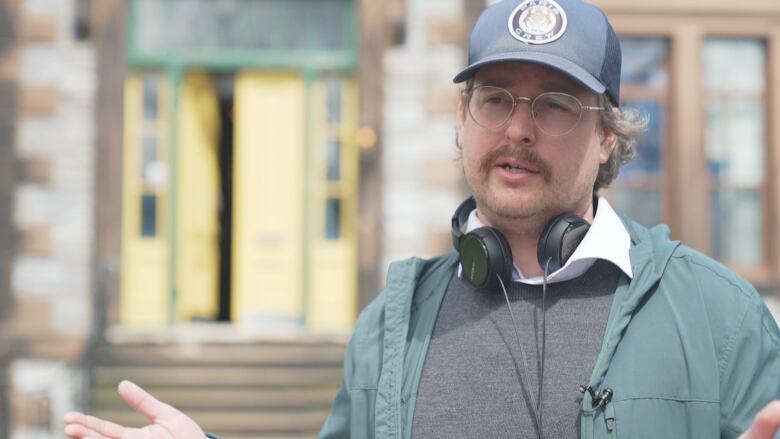 A man with over-ear headphones around his neck