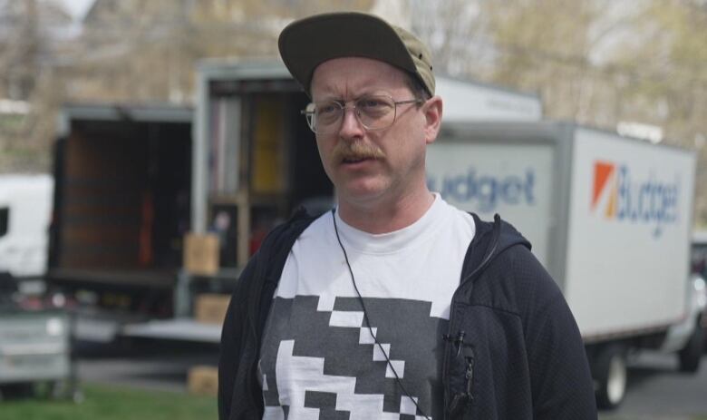 A man wearing glasses and a cap