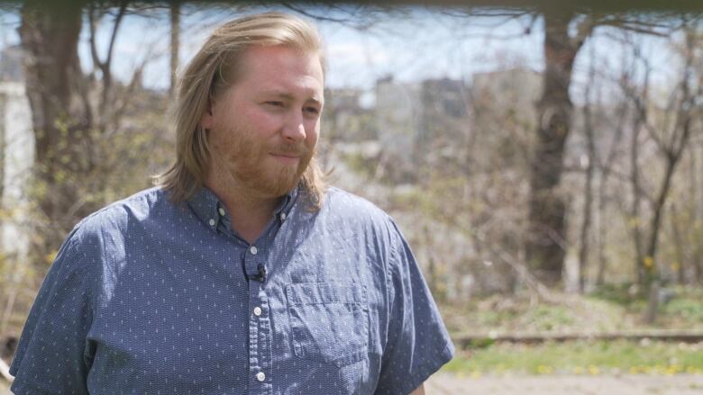 A man with blond hair wearing a blue button-up shirt