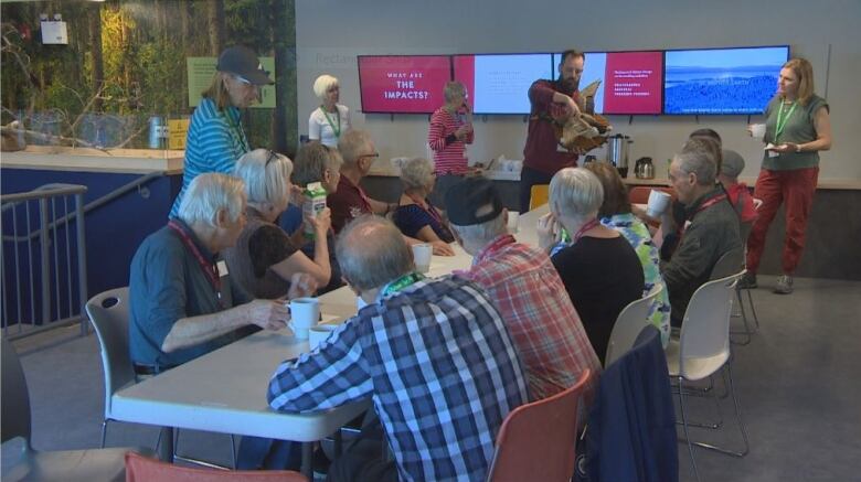 People sit at a table, drinking coffee.