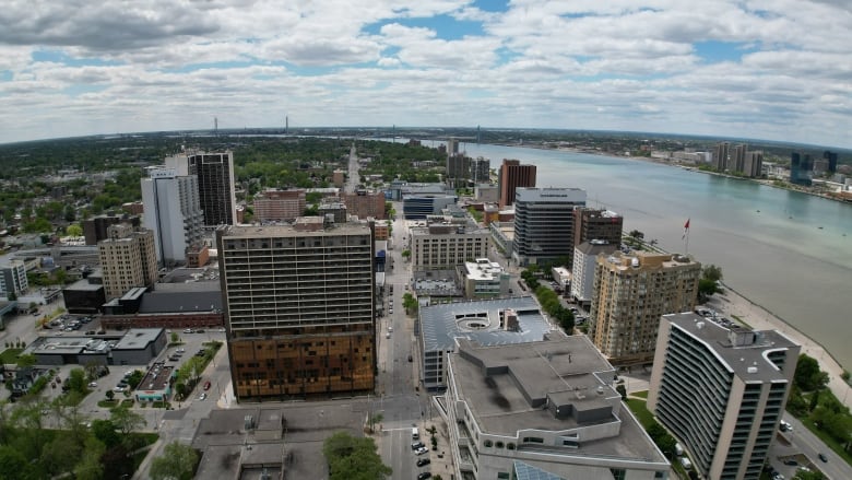 An aerial shot of buildings and the Detroit River.