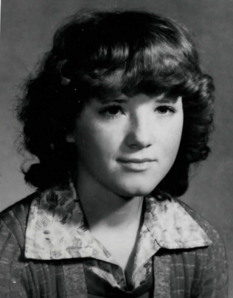 A black and white photo of a teenaged girl with wavy dark hair.