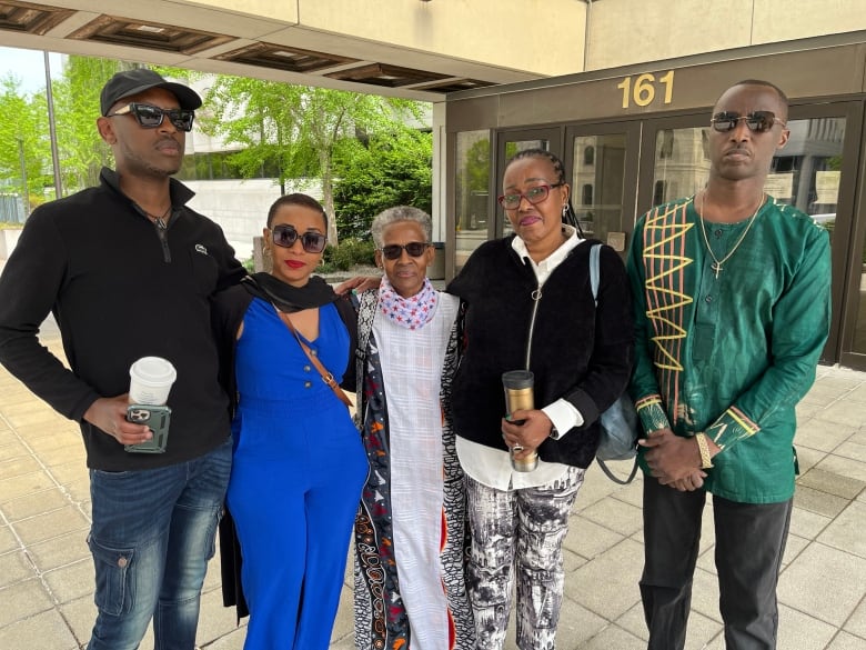 Family members and friends of two men who passed away in a car crash stand together outside court after a plea hearing for the other driver. 