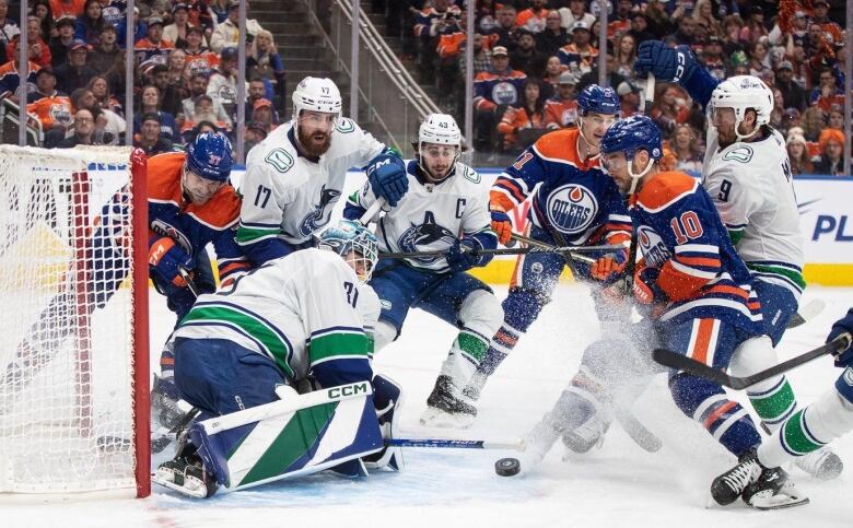 Ice hockey players battle it out in the ice rink trying to score