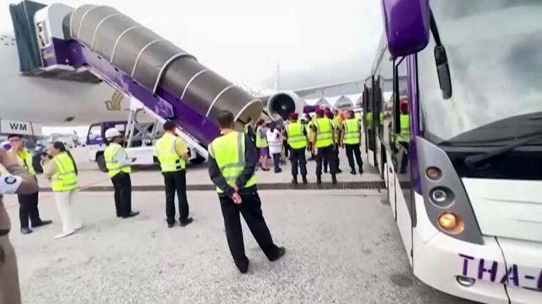 Emergency workers stand near an aircraft.