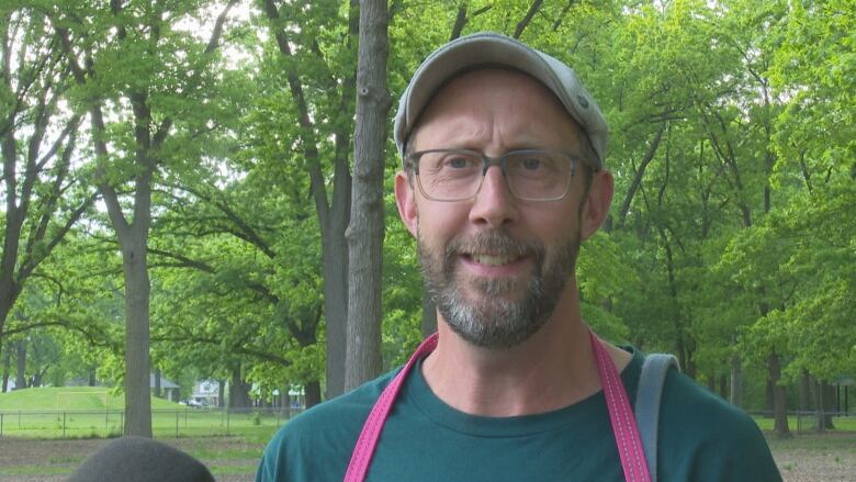 A man wearing glasses in a park.