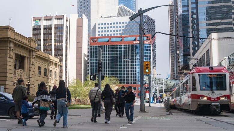 People and vehicles move through downtown Calgary on May 4, 2024.  