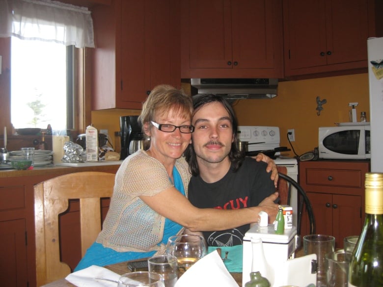 Nancy and Ben sit at a kitchen table together. 