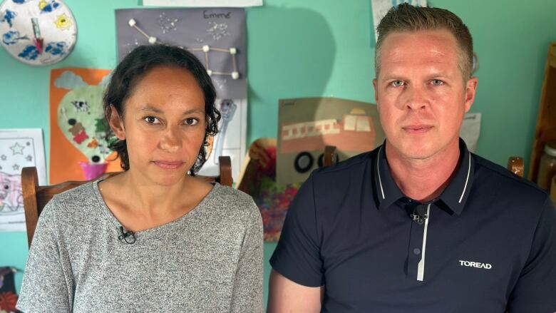 A man and a woman sit at a kitchen table. 