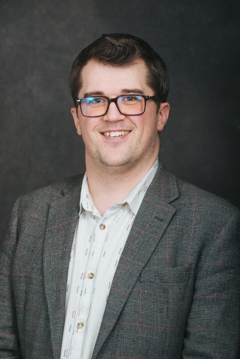 Man in blazer smiles. 