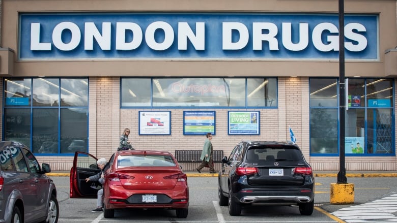 A large store with people walking in, with a sign reading 'London Drugs'.