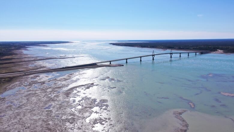 A long bridge across a river is seen from afar.