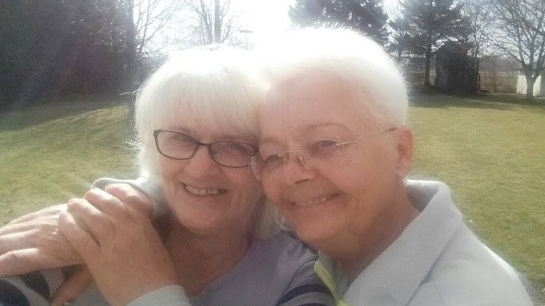 Two senior-age women embrace.