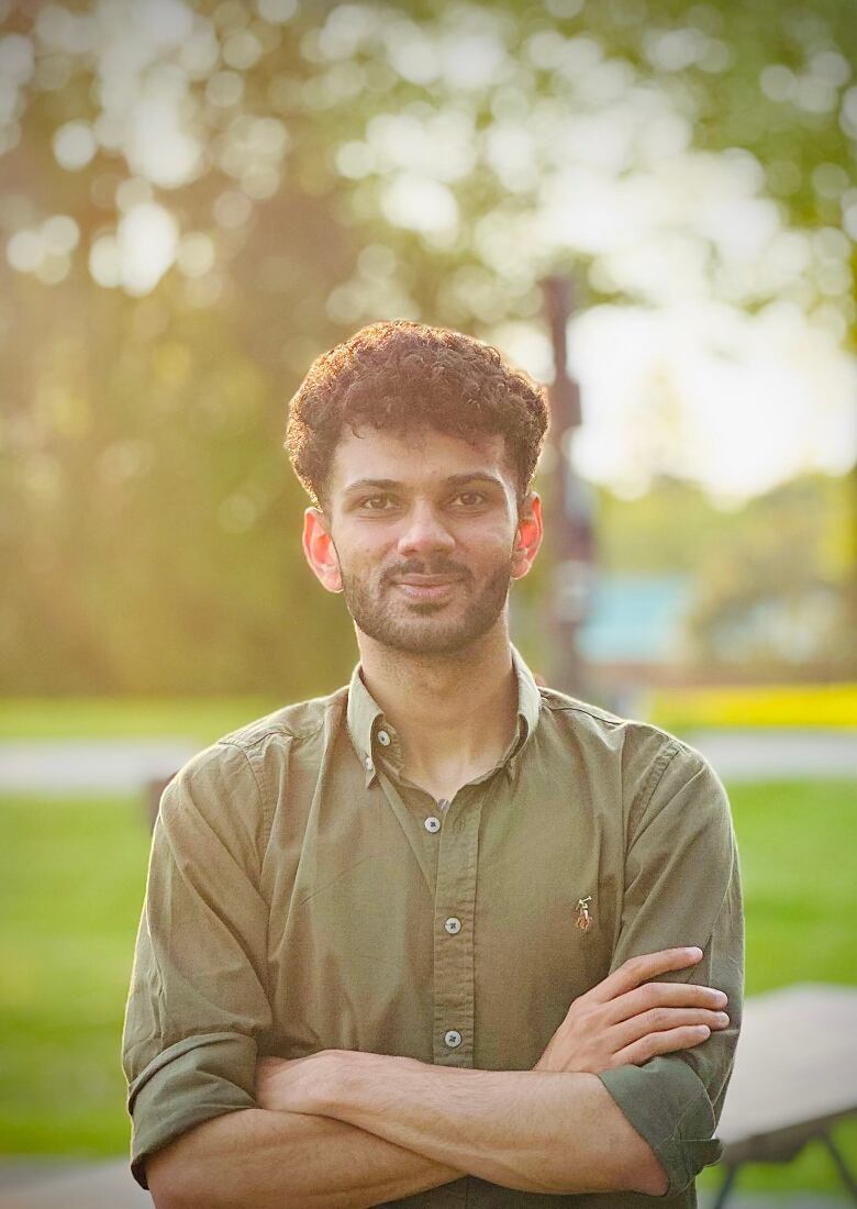 Person looking at the camera in a formal shirt, dappled light