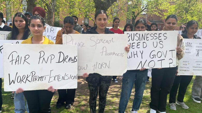 Around 150 newcomers stood silently outside the Coles Building in Charlottetown on Thursday during a legislative standing committee meeting about the P.E.I. government's changes to its immigration policies.