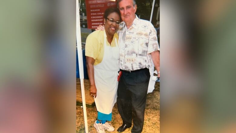 A woman and a man hugging and posing for a photo.